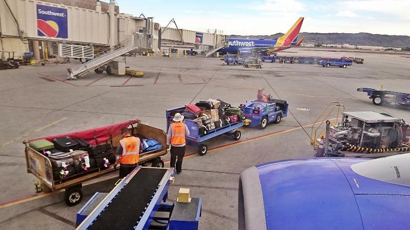 Ramp agents load passenger luggage and cargo onto Southwest Airlines flight at Phoenix Sky Harbor Airport 